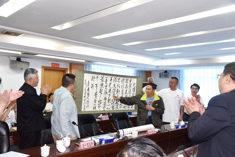 图七：展示墨宝，并赠送给徐闻.jpg