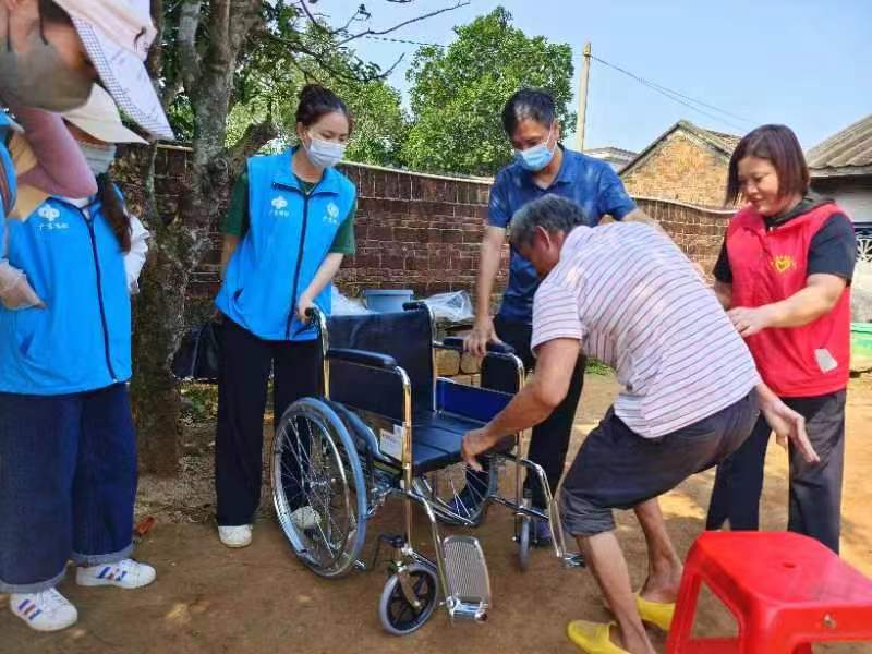助残日：给残疾人赠送轮椅.jpg