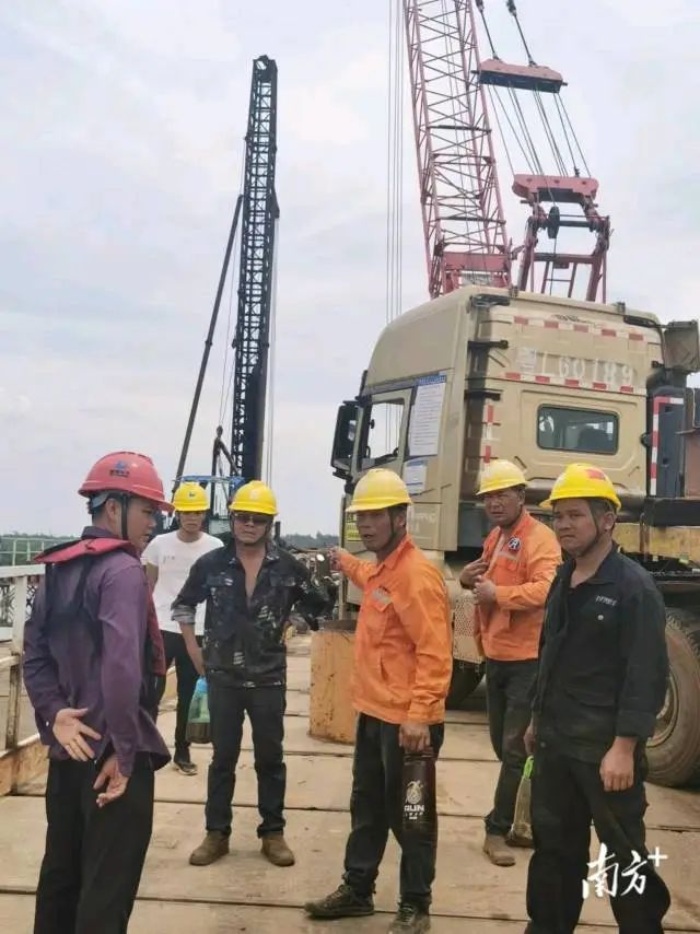 施工人员酷暑下研讨施工方案。 图片